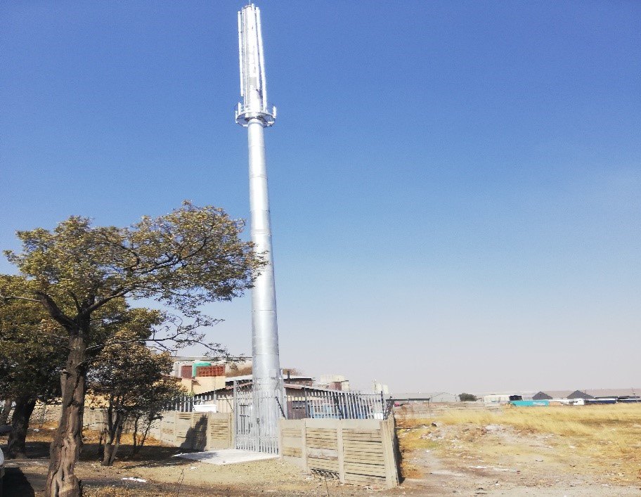 Monopole tower with antennas against a clear sky